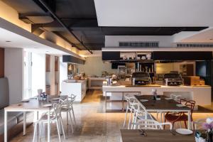 
a kitchen with a table, chairs and a refrigerator at S15 Sukhumvit Hotel- SHA Extra Plus in Bangkok
