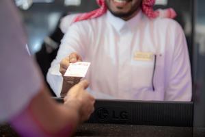 a man holding a piece of paper in his hand at Y Platinum Hotel in Al Madinah