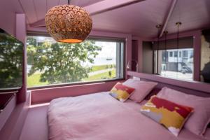 a bedroom with a large bed and a large window at Loods Logement in Oost-Vlieland