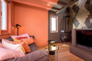 
a living room with a fireplace and a bed at Loods Logement in Oost-Vlieland
