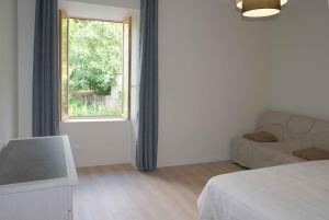 a white room with a bed and a window at la sereine in Pech