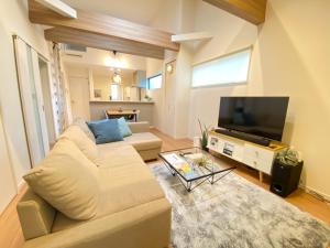 uma sala de estar com um sofá e uma televisão de ecrã plano em AddressHokancho em Okayama