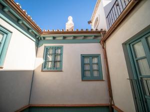 a building with blue windows and a balcony at Casas de Sevilla - Apartamentos Vidrio 7 in Seville