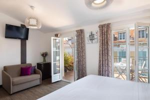 a bedroom with a bed and a chair and a window at Hotel Florence Nice in Nice