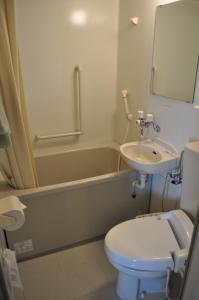 a bathroom with a toilet and a sink and a tub at Hotel Los Inn Kochi in Kochi