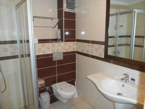 Hotel Kovarna في ديشين: حمام مع حوض ومرحاض ومرآة