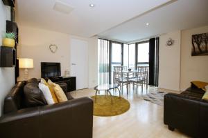 una sala de estar con un sofá y una mesa en Riverview Apartments, en Glasgow