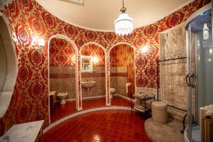 Palo del ColleにあるB&B Savariniの赤と金の壁紙を使用したバスルーム、トイレ