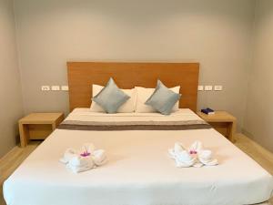 a bedroom with a white bed with two towels at Behind The Scene Hotel Club @ Samui in Chaweng