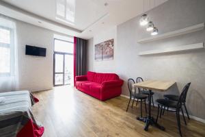 a living room with a red couch and a table at Lviv4U in Lviv
