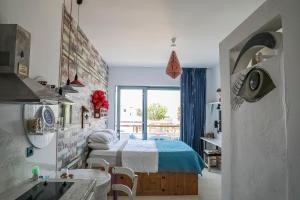 a bedroom with a bed and a kitchen with a window at Pefkos Eye in Pefki Rhodes