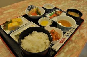 um tabuleiro com arroz e outros alimentos sobre uma mesa em Hotel Los Inn Kochi em Kochi