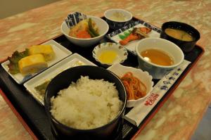 a tray with rice and other foods on a table at Hotel Los Inn Kochi in Kochi