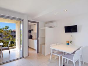 een keuken en eetkamer met een witte tafel en stoelen bij Apartment MB4 piscine by Interhome in Moriani Plage