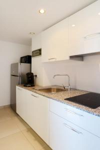 een witte keuken met een wastafel en een koelkast bij Apartment MB4 piscine by Interhome in Moriani Plage