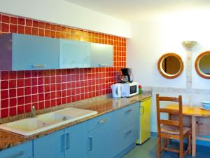 リル・ルッスにあるApartment Résidence de la Plage - IRU153 by Interhomeの赤いタイルの壁、シンク付きのキッチン