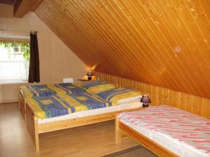 1 Schlafzimmer mit 2 Betten und einer Holzwand in der Unterkunft Apartment Old Hüsung - MUZ327 by Interhome in Mirow
