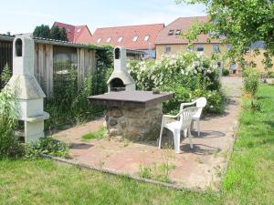 eine Terrasse mit einem Tisch und einem Steinofen im Hof in der Unterkunft Apartment Old Hüsung - MUZ327 by Interhome in Mirow