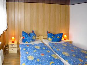 Schlafzimmer mit einem Bett mit blauer Bettwäsche und Kissen in der Unterkunft Apartment Old Hüsung - MUZ321 by Interhome in Mirow
