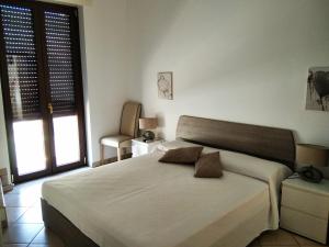 a bedroom with a large white bed with two pillows at b&b La Lucertola casa vacanze in Carovigno