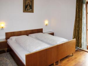 a bed with a wooden frame in a bedroom at Apartment Zollerhof - OLA192 by Interhome in Valdaora di Sotto