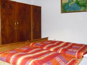 Ce lit se trouve dans une chambre dotée d'une armoire en bois. dans l'établissement Apartment Zollerhof - OLA192 by Interhome, à Niederolang