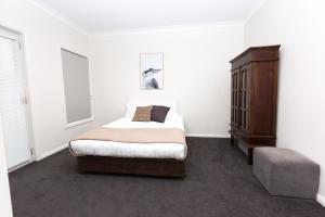 une chambre blanche avec un lit et une commode dans l'établissement Glen’s Inner City Escape - CBD Central, à Wagga Wagga