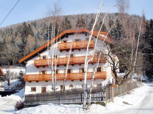 a building in the snow with trees in front of it at Apartment Zollerhof - OLA190 by Interhome in Valdaora di Sotto