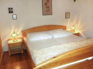 sypialnia z drewnianym łóżkiem i 2 szafkami nocnymi w obiekcie Apartment Kunzhof-2 by Interhome w mieście Winklern