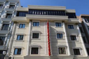 a white building with a red flag on it at Ceylan Hotel in Bursa