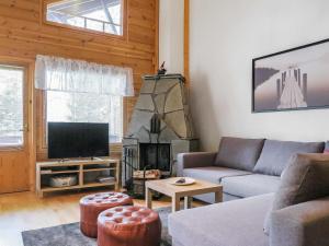 ein Wohnzimmer mit Couch und Kamin in der Unterkunft Holiday Home Artturi by Interhome in Levi