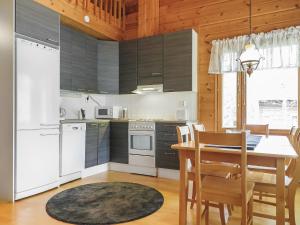 eine Küche mit weißen Geräten und einem Tisch mit Stühlen in der Unterkunft Holiday Home Artturi by Interhome in Levi + 14 Fotos