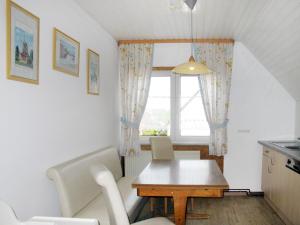 eine Küche und ein Esszimmer mit einem Tisch und einem Fenster in der Unterkunft Apartment Hannemann-2 by Interhome in Schillig