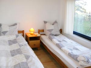 two twin beds in a room with a window at Holiday Home Silz am Fleesensee-3 by Interhome in Silz