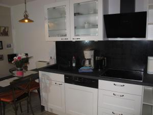 a kitchen with white cabinets and a black counter top at Apartment Bela 2 by Interhome in Nonnevitz