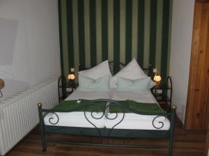 a bed with green and white sheets and pillows at Apartment Bela 2 by Interhome in Nonnevitz