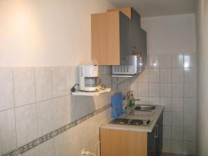 uma pequena cozinha com um lavatório e um micro-ondas em Apartment Gottwald - SRD305 by Interhome em Starigrad-Paklenica