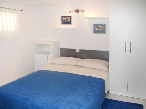 a small bedroom with a bed with a blue blanket at Apartment Gottwald - SRD305 by Interhome in Starigrad