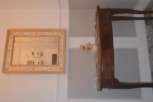 a mirror on a wall with a wooden frame at Vintage Home in Monopoli