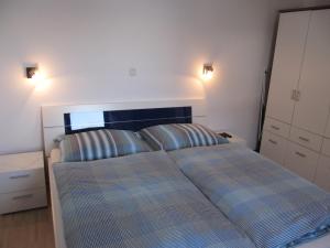 ein Schlafzimmer mit einem Bett mit zwei gestreiften Kissen in der Unterkunft Ferienwohnung Salzmann in Innsbruck