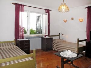 a bedroom with two beds and a table and a window at Apartment Branka-1 by Interhome in Mošćenice +11 photos