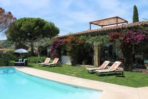 a villa with a swimming pool and chairs and a house at La Villa Topi in Antibes