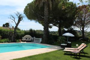 a swimming pool with a chair and an umbrella at La Villa Topi in Antibes