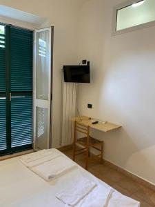 a bedroom with a bed and a desk and a television at Hotel Nuovo Metropol in Albissola Marina
