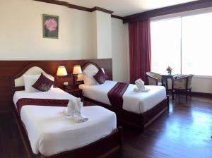 Postel nebo postele na pokoji v ubytování Arawan Riverside Hotel