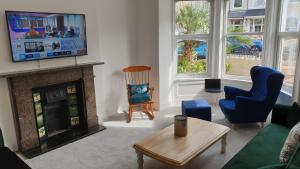 Una sala de estar con chimenea y televisión. en Snowdon Retreat Villa by Seaside Llandudno, en Llandudno