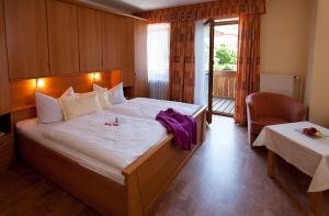 una habitación de hotel con una cama grande y una silla en Landhotel Gruber, en Waldmünchen