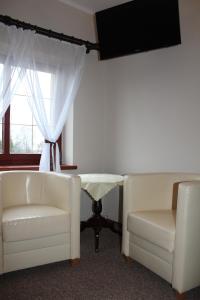 une chambre avec deux chaises, une table et une fenêtre dans l'établissement Zajazd Podlesie, à Chociwel