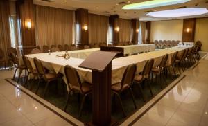 ein großer Konferenzraum mit einem langen Tisch und Stühlen in der Unterkunft Park Hotel in Volos