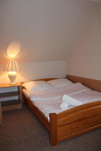 łóżko w pokoju z lampką i łóżko sidx sidx sidx w obiekcie Zajazd Podlesie w mieście Chociwel